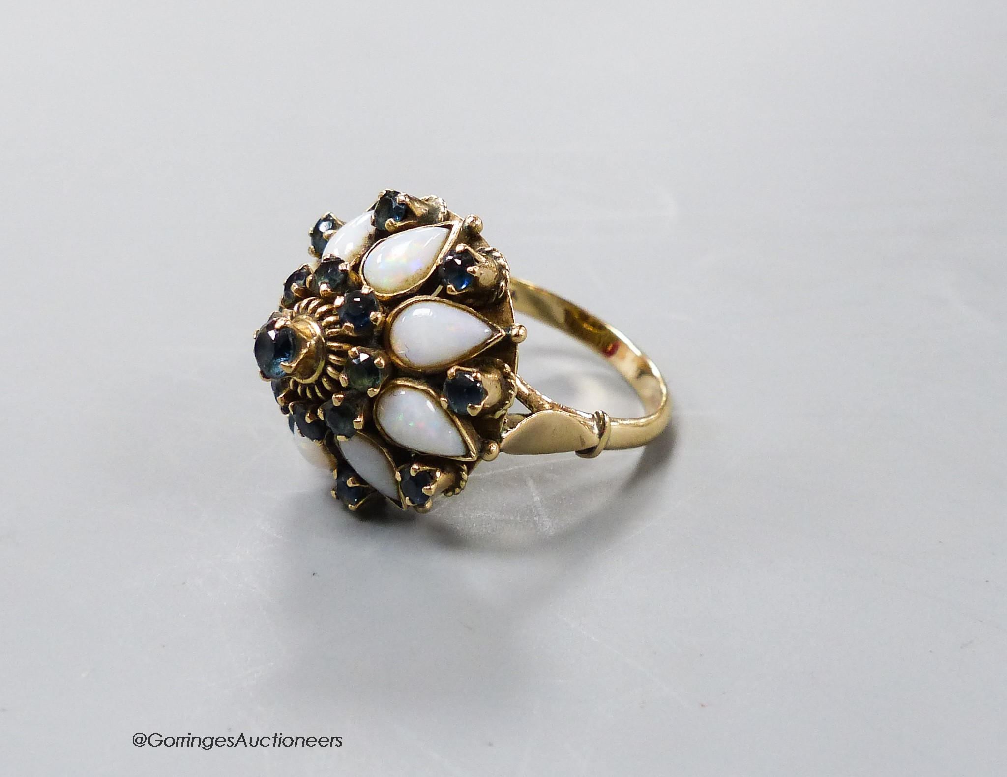 A yellow metal (stamped 18k), white opal and sapphire cluster set 'hareem' ring, size O, gross 6.6 grams.